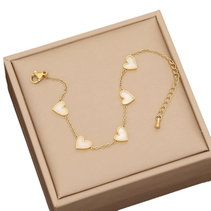 Golden heart charm necklace with white shell inlays presented in an elegant jewelry box