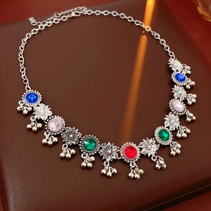 Detailed shot of silver-tone vintage floral necklace with colorful stones and small bells