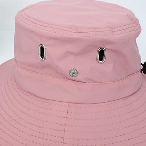 Detail of pink hiking hat featuring metal eyelets, side snaps, and precise brim stitching