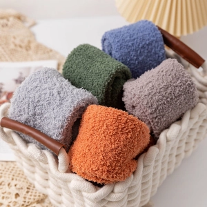 Plush coral fleece over-the-knee socks in various colors displayed in a woven basket