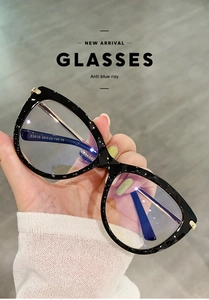 Dettaglio occhiali cat-eye anti luce blu con cerniere a molla in metallo e montatura nera opaca