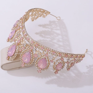 Close-up of golden bridal tiara featuring large pink teardrop gems and rhinestones