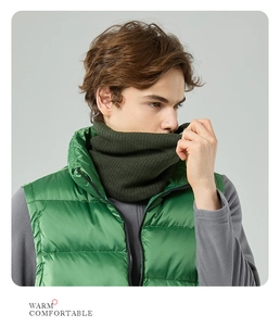 Detail view of dark green ribbed knit neck warmer paired with a bright green quilted vest