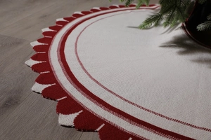 Dettaglio della gonna per albero di Natale a righe bianche e rosse su pavimento in legno