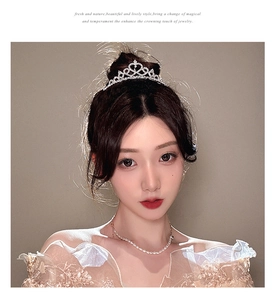 Close-up of sparkling rhinestone heart tiara and pearl necklace on an elegant bride