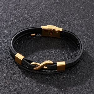 Detail of men's leather bracelet with golden infinity symbol and magnetic clasp