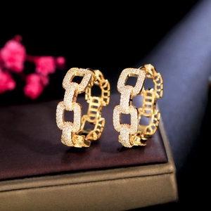 Close-up of golden chain link hoop earrings with pavé set white zircon stones
