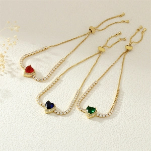 Close-up of gold heart bracelets with red, blue and green stones and white diamonds