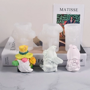 Trois moules en silicone de gnomes et figurines en plâtre sur fond de marbre