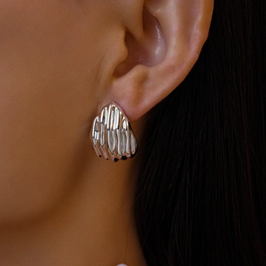 Vue détaillée de la boucle d'oreille géométrique en métal plissé argenté sur modèle