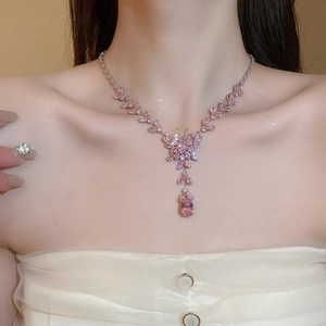 Close-up of a pink butterfly necklace with water drop pendant on a female model