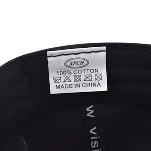 Detail of the internal washing label and 100% cotton fabric on a black baseball cap