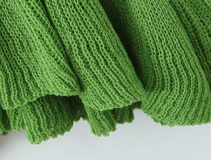 Vista macro dettagliata del tessuto in maglia crochet verde con trama intrecciata