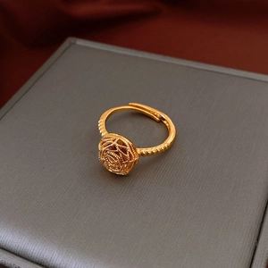 Détail d'une bague rose 3D dorée avec anneau ajustable sur un écrin à bijoux