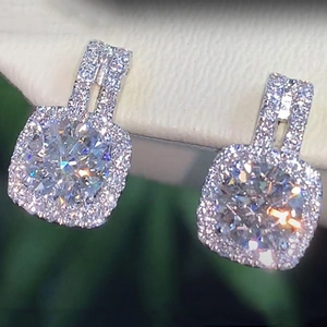 Macro shot of cushion-shaped halo stud earrings with silver finish and brilliant zircon