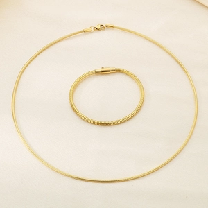 Detailed view of polished 18K gold plated snake chain necklace and matching bracelet set