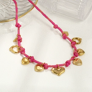 Rose red braided necklace with golden heart charms on a clean white textured surface
