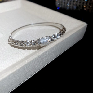 Macro view of silver bracelet featuring braided texture and square cubic zirconia center