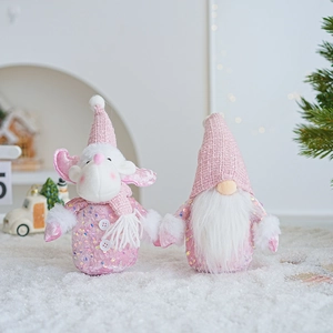 Detail of pink Christmas gnomes with sequins and knitted hats in a warm snow scene