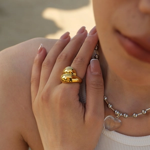 Détail macro d'une bague dorée style lave bombée avec finition miroir poli sur mannequin