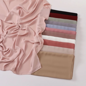 Detail view of pink satin hijab scarf with diverse color palette and rolled edge finishing