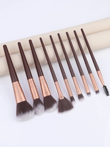 Macro detail of 10-piece makeup brush set with rose gold ferrules on leather roll