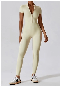 Detail of front zipper neckline on cream short sleeve yoga bodysuit with slim fit fabric