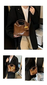 Detail view of brown vintage leather tote with metallic charm and crossbody strap styling