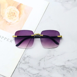 Frameless rimless sunglasses with purple gradient lenses and gold bridge on marble