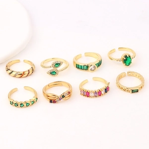 Detailed view of adjustable gold rings featuring emerald and ruby cubic zirconia stones