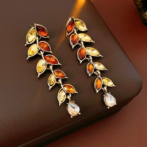 Détail de boucles d'oreilles vintage en bronze avec strass ambrés et pampille de blé