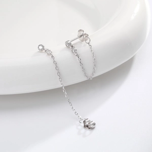 Vue détaillée de boucles d'oreilles chaînes en argent avec zircons sur une plaque en céramique