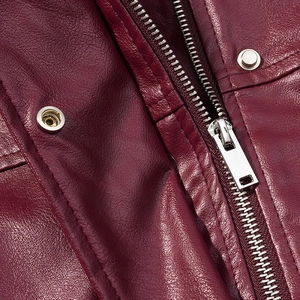 Detailed macro shot of silver metal zippers and buttons on a burgundy leather jacket