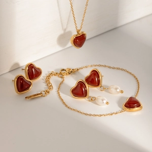 Golden heart jewelry set featuring heart necklace, bracelet, earrings and white pearls