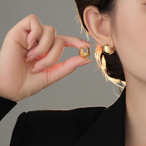 Detail showing high-polish gold ball hoop earring size and elegant look on model