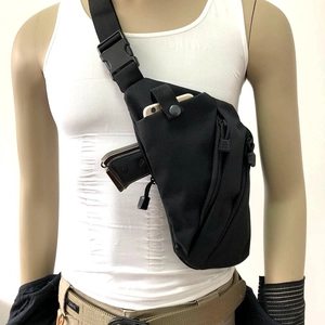 Detail of multi-pocket black tactical crossbody bag with concealed holster worn on body
