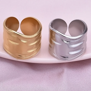 Detail of wide hammered texture open rings in gold and silver finish on silk