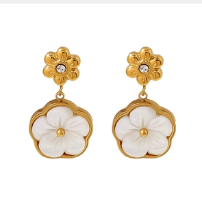 Détail de boucles d'oreilles florales en acier doré 18K avec nacre blanche et cristaux