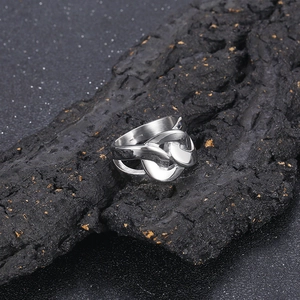 Close-up of polished silver steel interlocking chain link ring on textured stone