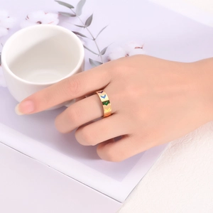 Close-up of a gold V-shaped rainbow ring on a finger in a minimalist lifestyle setting
