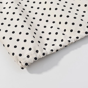 Detailed macro view showing the elastic drawstring hem and stitching of polka dot shorts