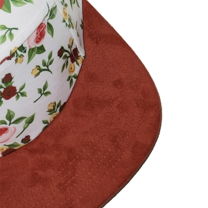 Detailed view of floral canvas cap crown and premium brown suede flat brim stitching