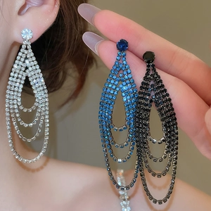 Détail de boucles d'oreilles pendantes avec pampilles en gouttes d'eau de trois couleurs