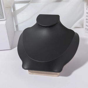 Detail of minimalist necklace display stand with black matte finish and wooden base