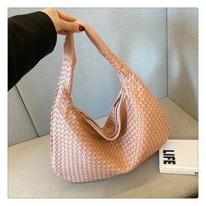 Close-up of pink woven PU leather shoulder bag featuring a stylish braided texture