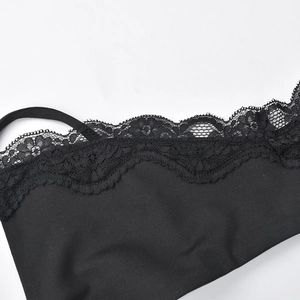Close-up of intricate black lace trim and knitted fabric on a beach strap dress