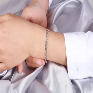 Classic 925 sterling silver Figaro chain bracelet worn over silver silk fabric