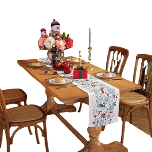 Modern Christmas table runner with reindeer and snowflake prints on a wooden dining table
