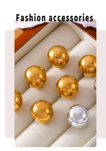 Close-up of gold and silver ball earrings with mirror finish in a white velvet box