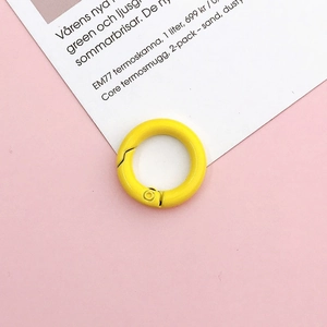 Bright yellow 20mm round spring ring fastener on pink background for DIY jewelry making